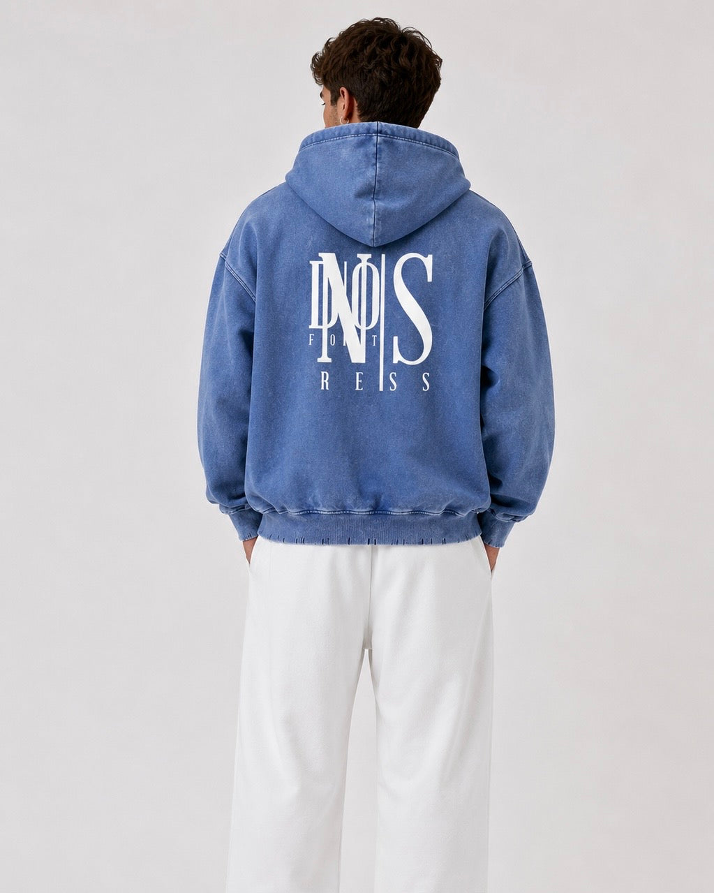 Person wearing a blue hoodie with a logo on the back against a white background