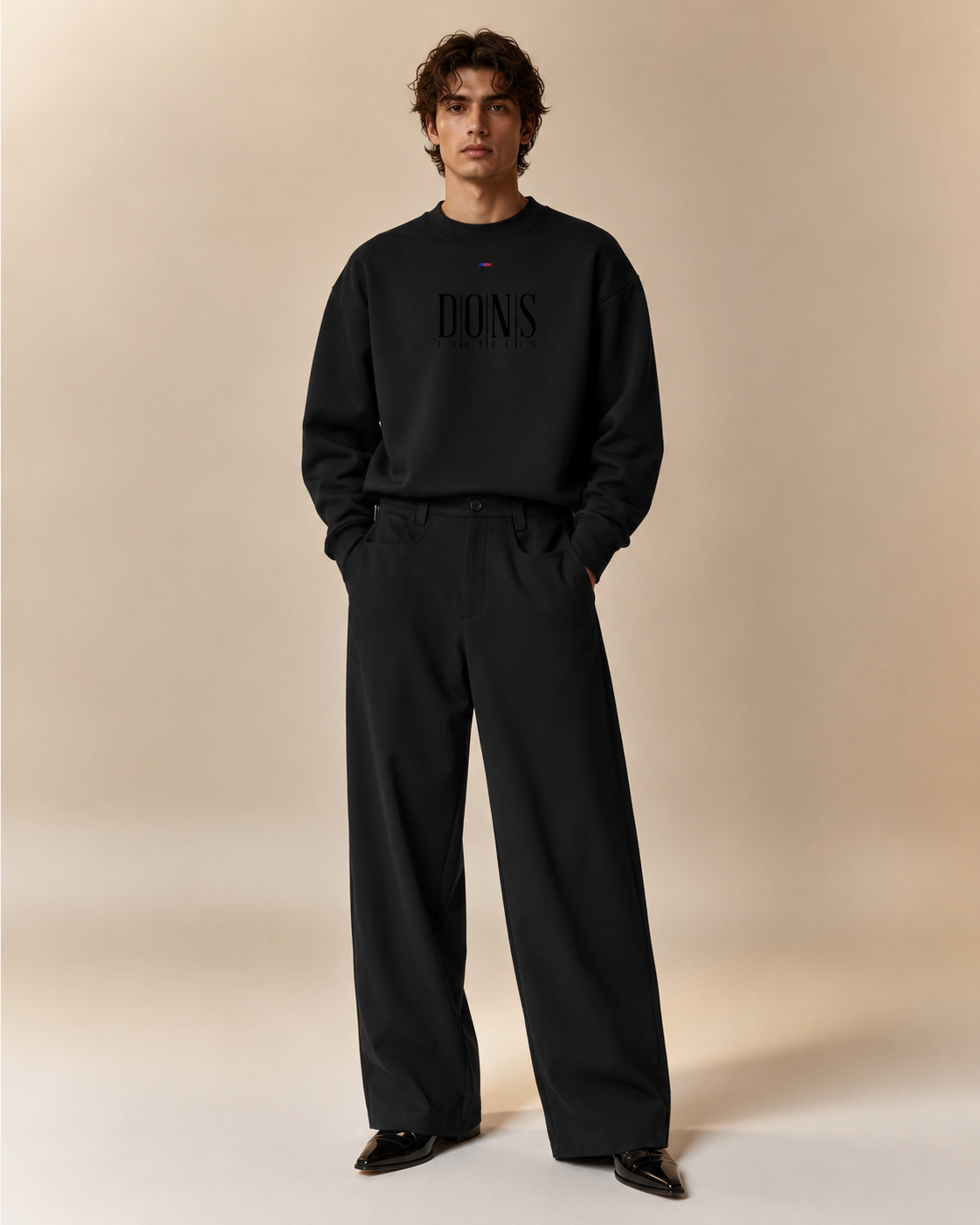Man wearing a black sweatshirt and pants with 'DONS FORTRESS' branding on a beige background