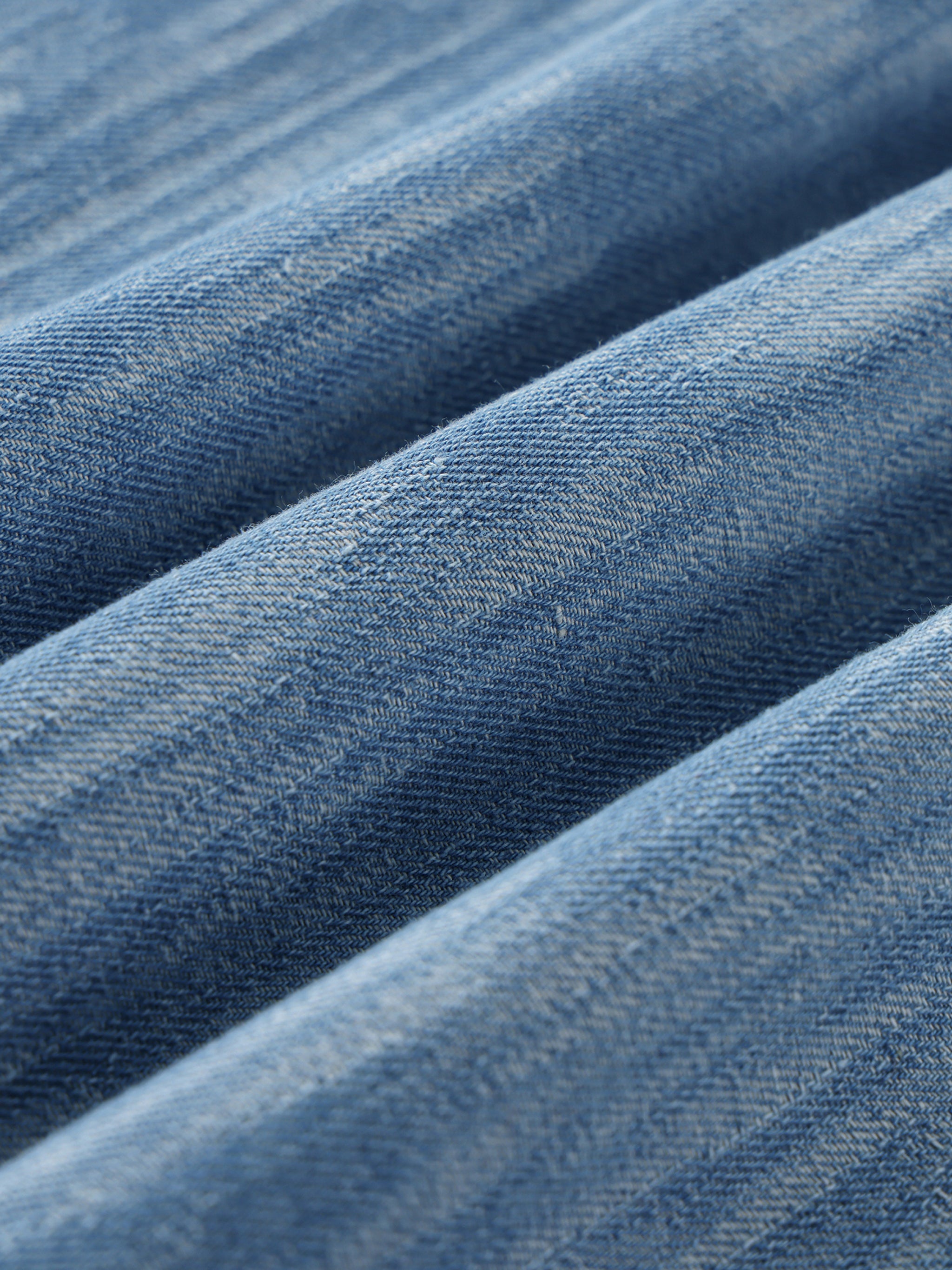 Close-up of blue denim fabric with a subtle pattern