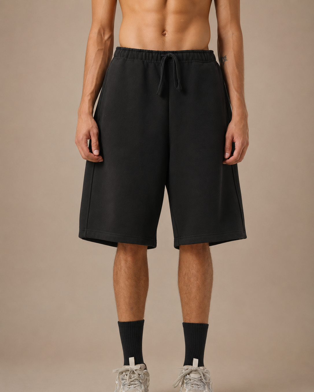 Person wearing black shorts on a beige background