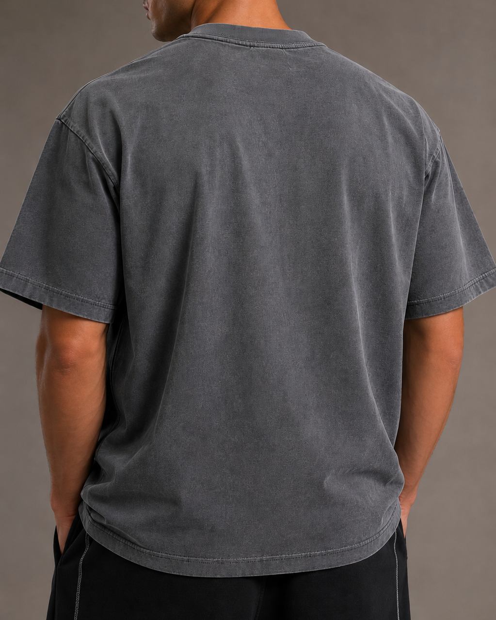 Man wearing a gray t-shirt against a plain background