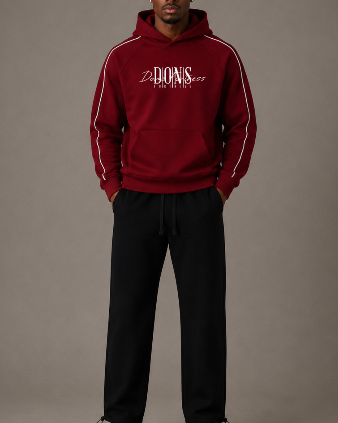 Person wearing a red hoodie with white text and black pants on a gray background