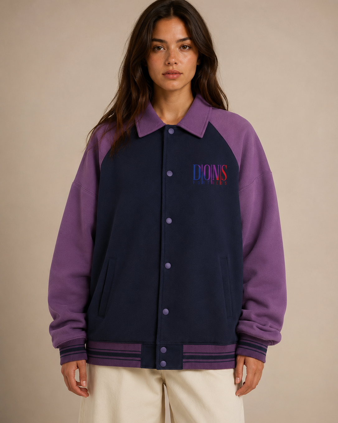 Person wearing a two-tone purple and navy jacket with branding on a beige background