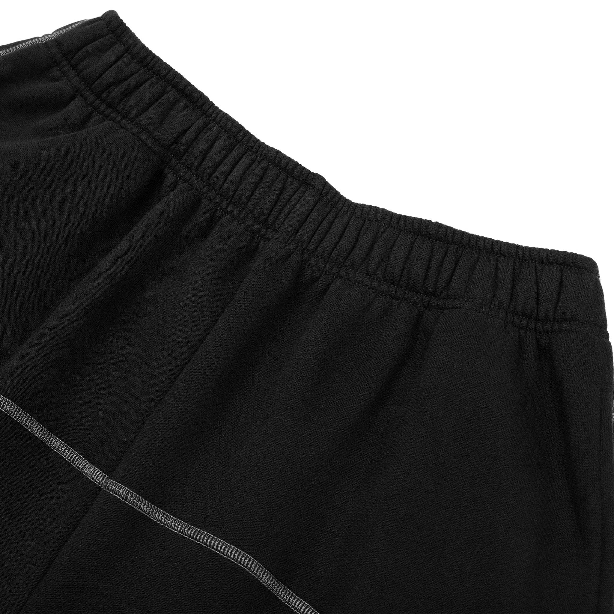 Close-up of black pants with a white background