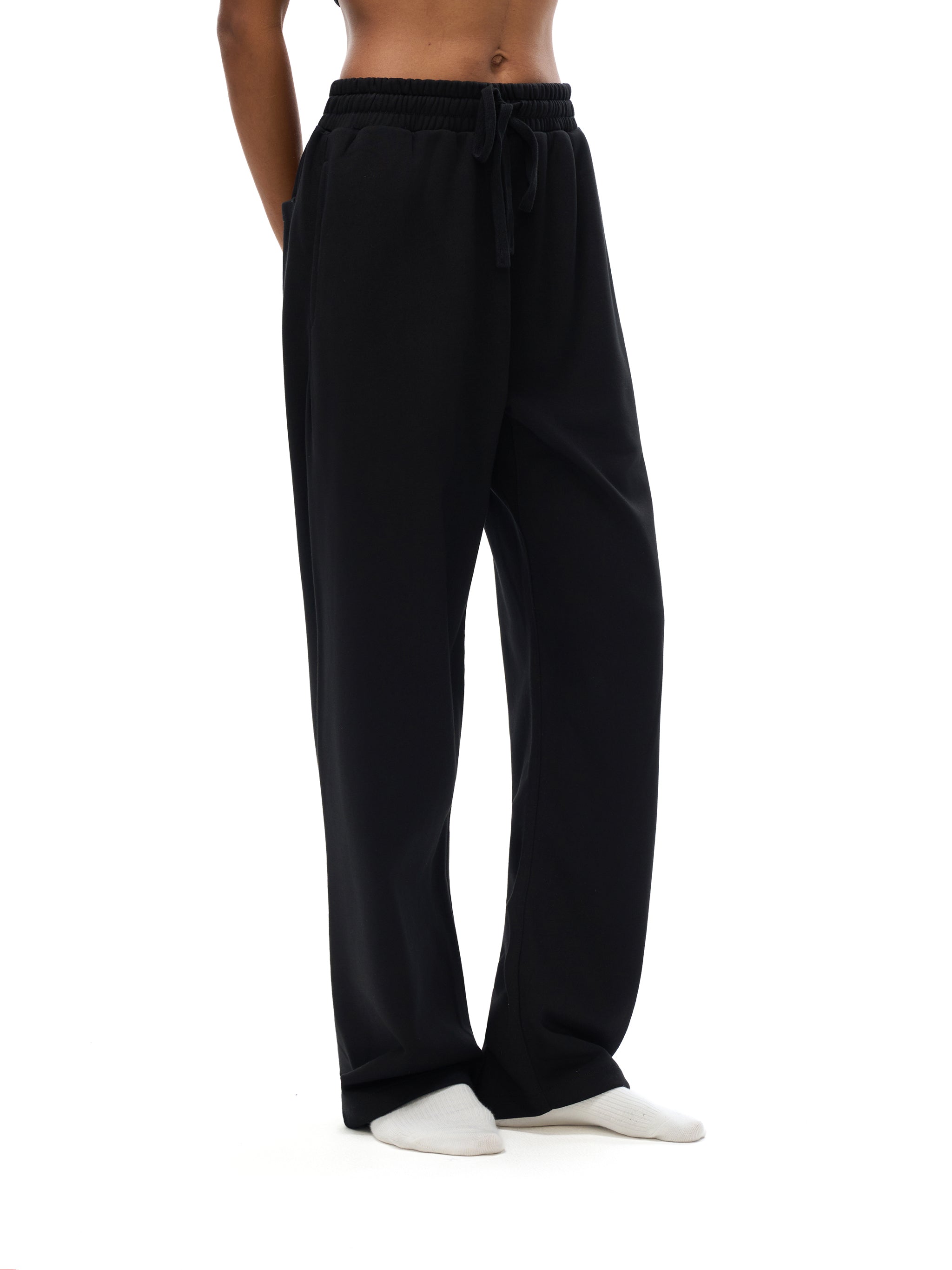 Black pants worn by a person on a white background