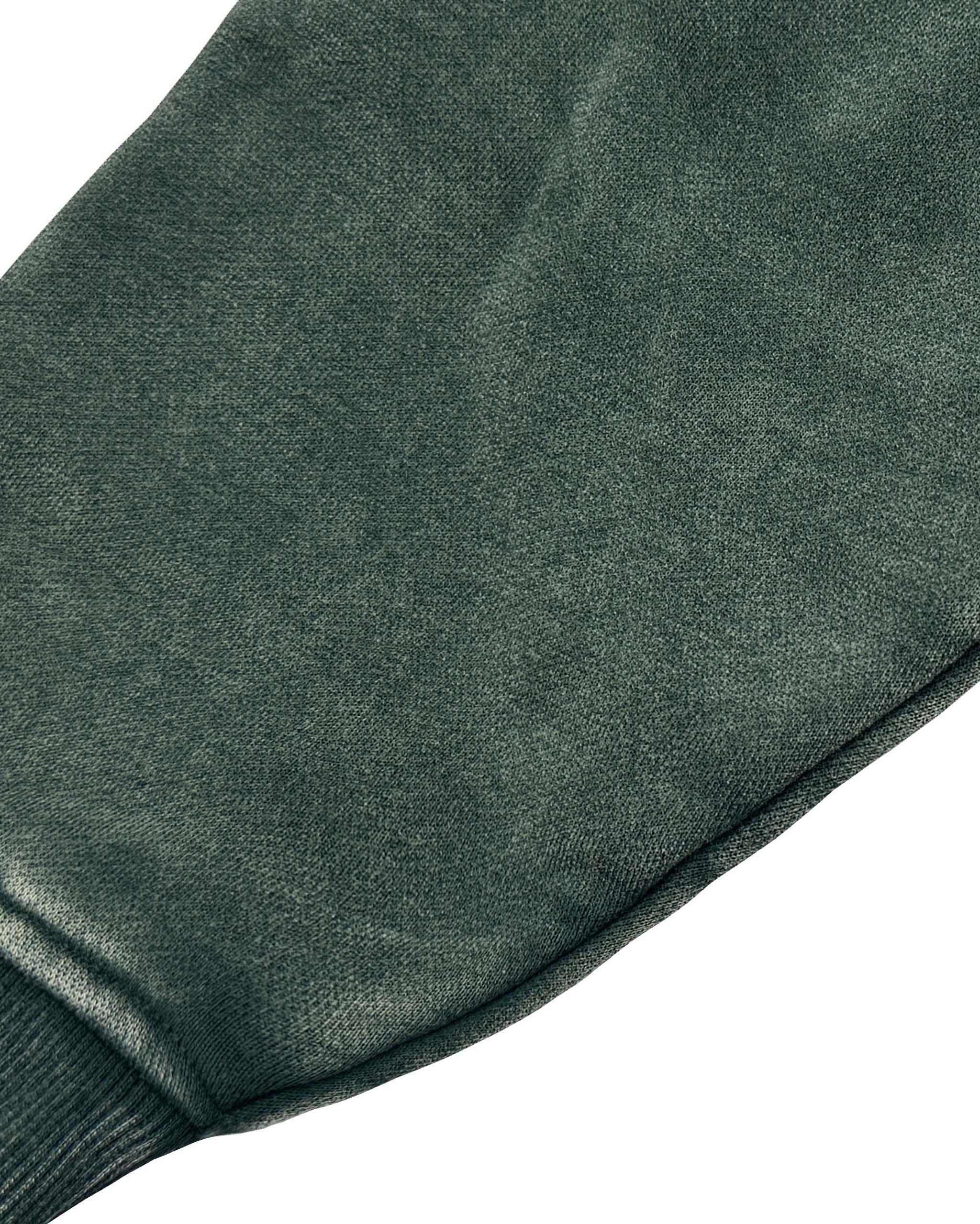 Close-up of a dark green fabric with a textured surface on a white background