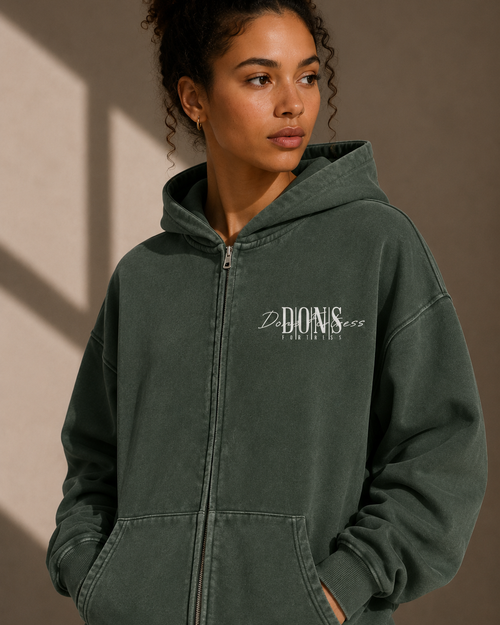 Person wearing a green hoodie with a brand logo on a beige background