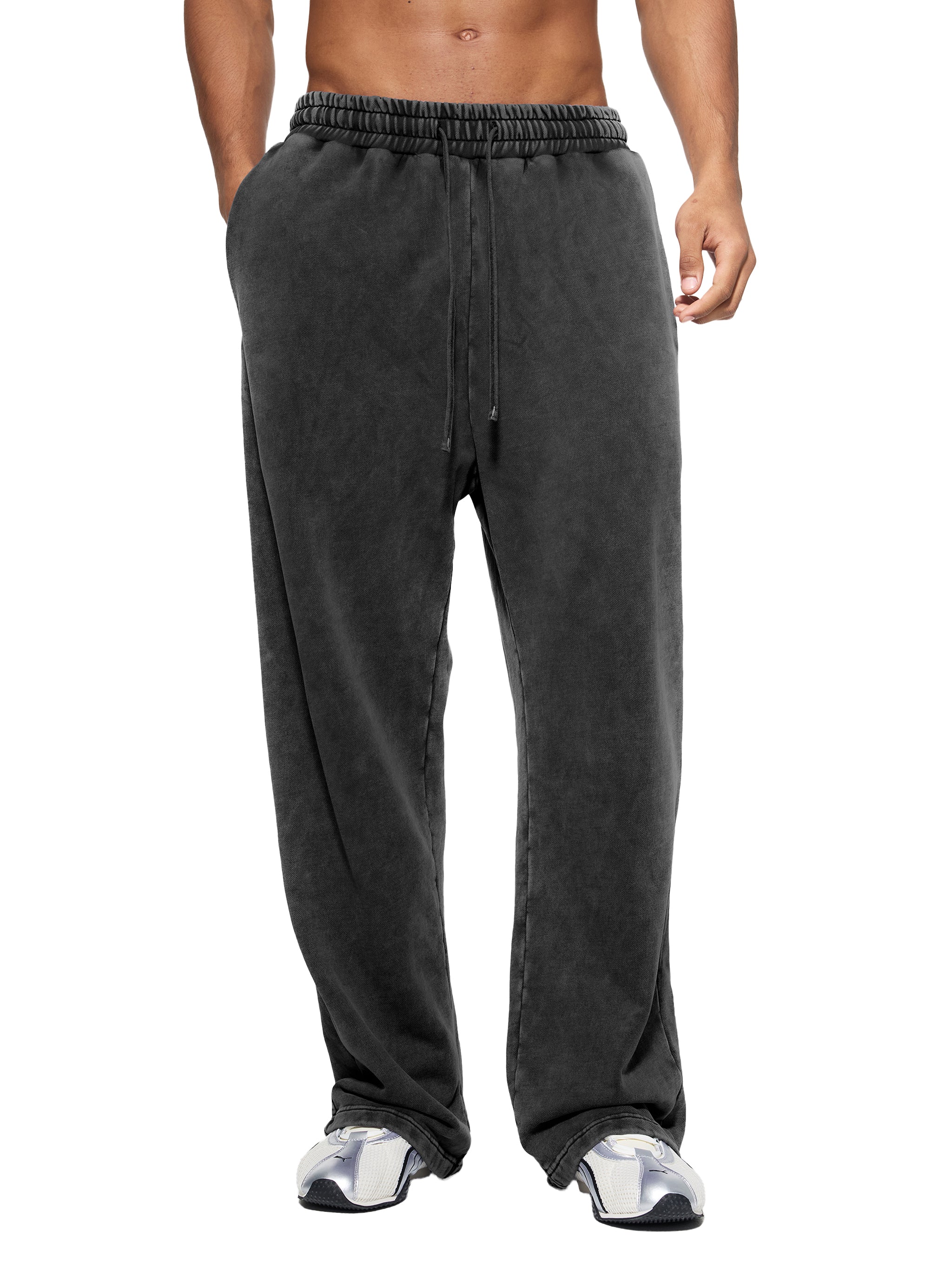 Person wearing dark gray sweatpants on a white background