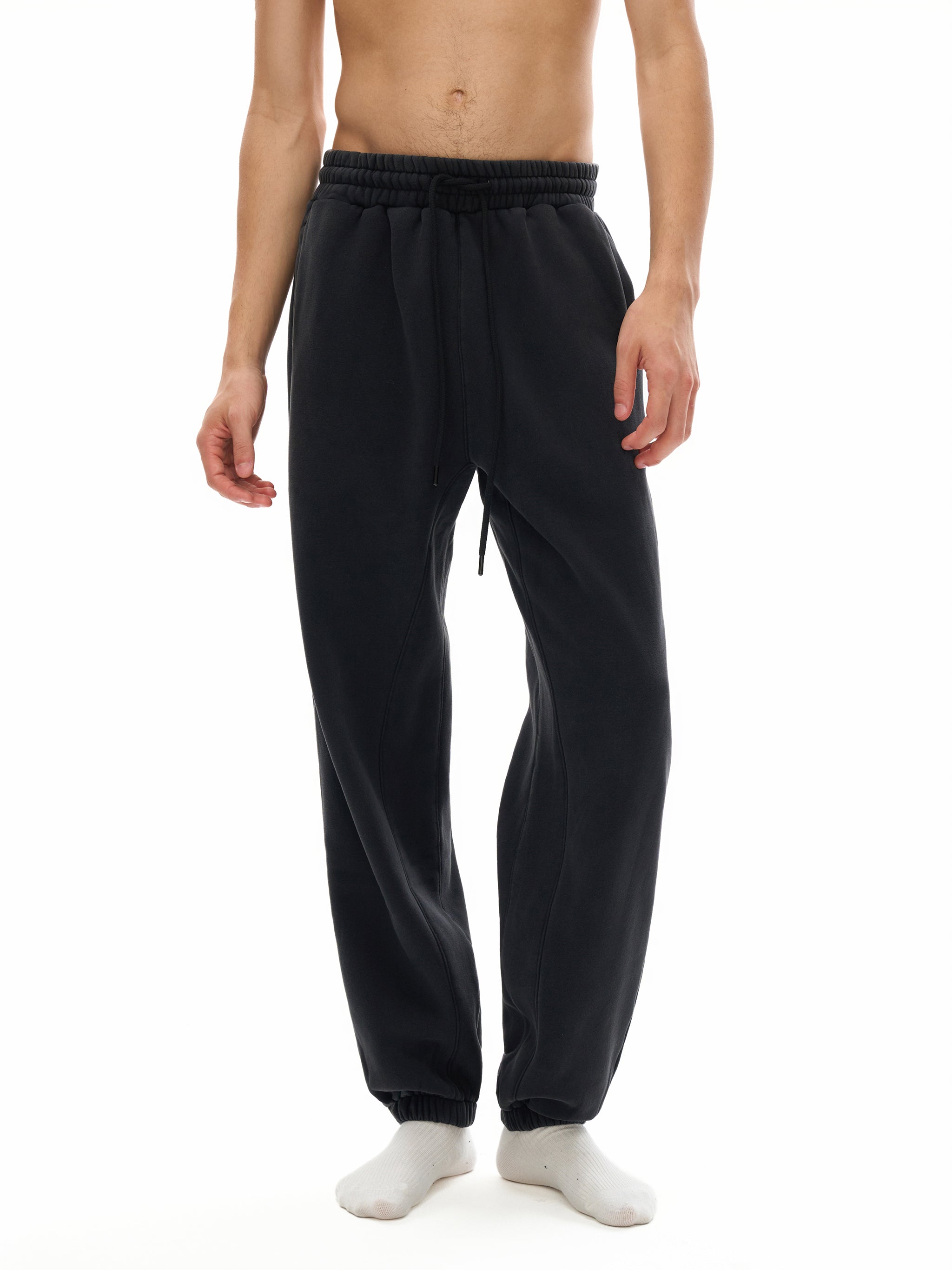 Person wearing black sweatpants on a white background