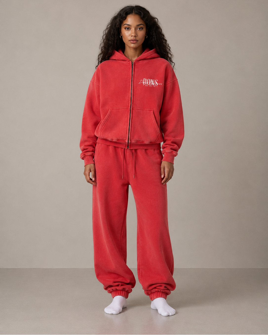 Person wearing a red tracksuit with a logo on a beige background