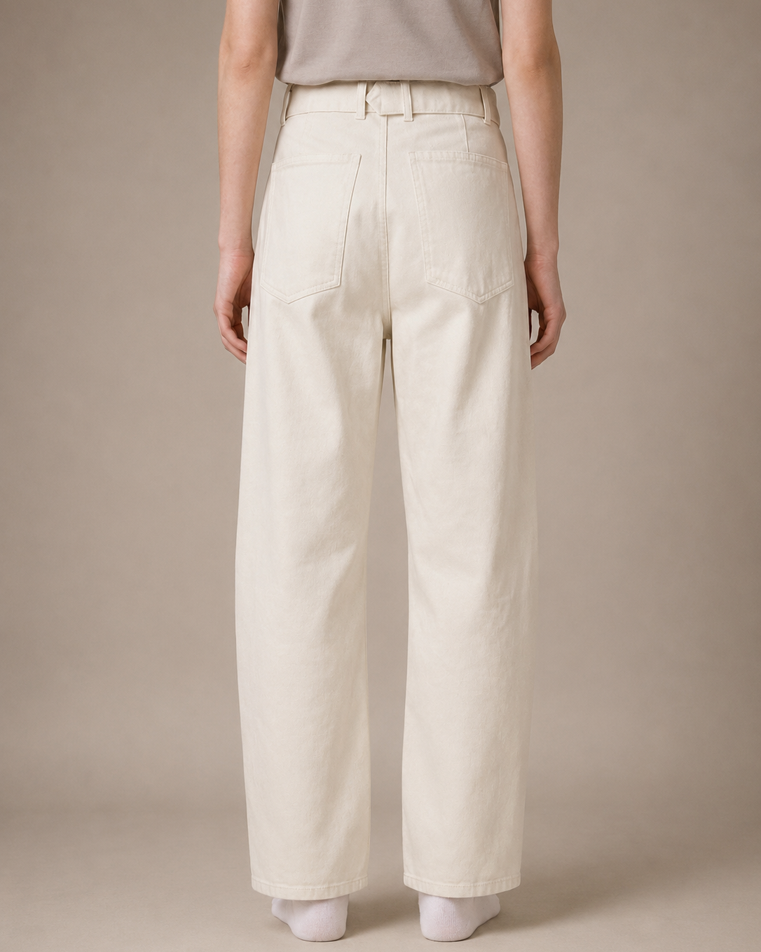 Person wearing beige wide-leg pants against a plain background