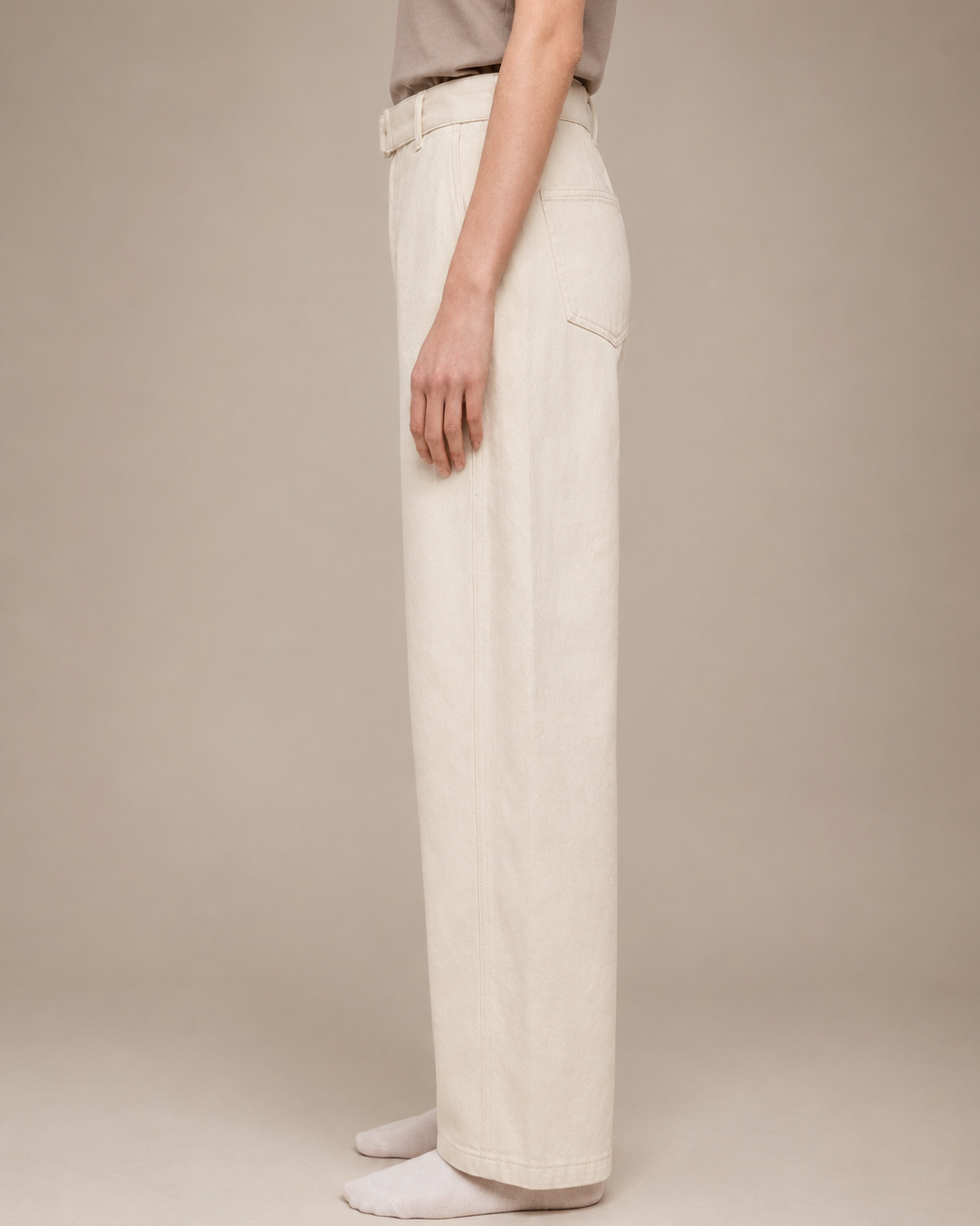 Person wearing beige pants on a plain background