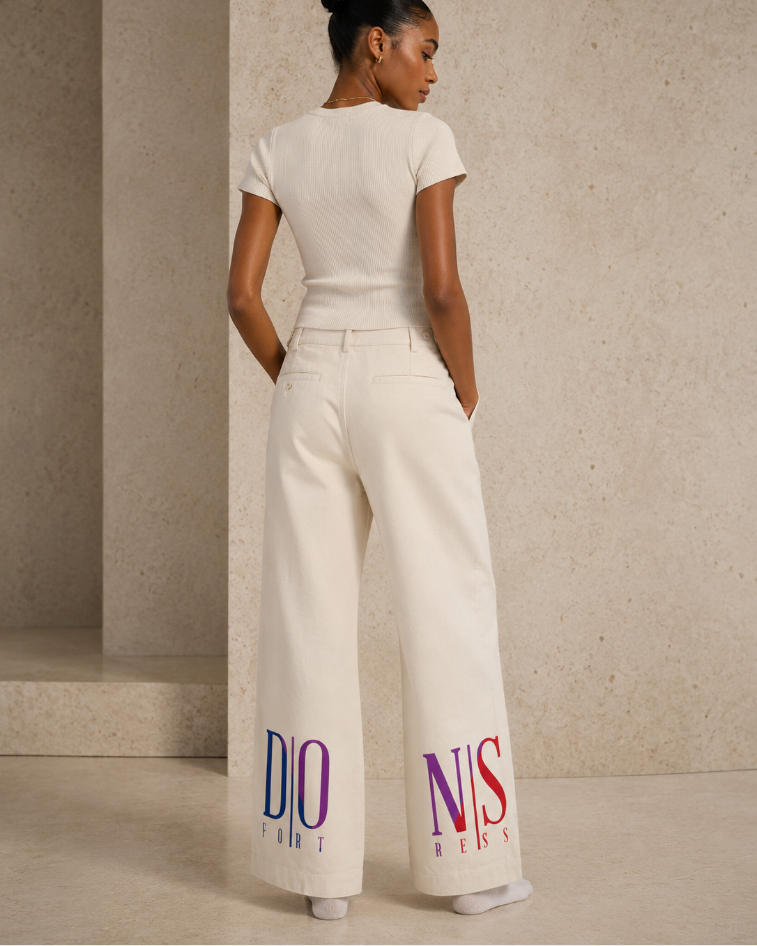 Woman wearing a white outfit with colorful text in an elegant setting
