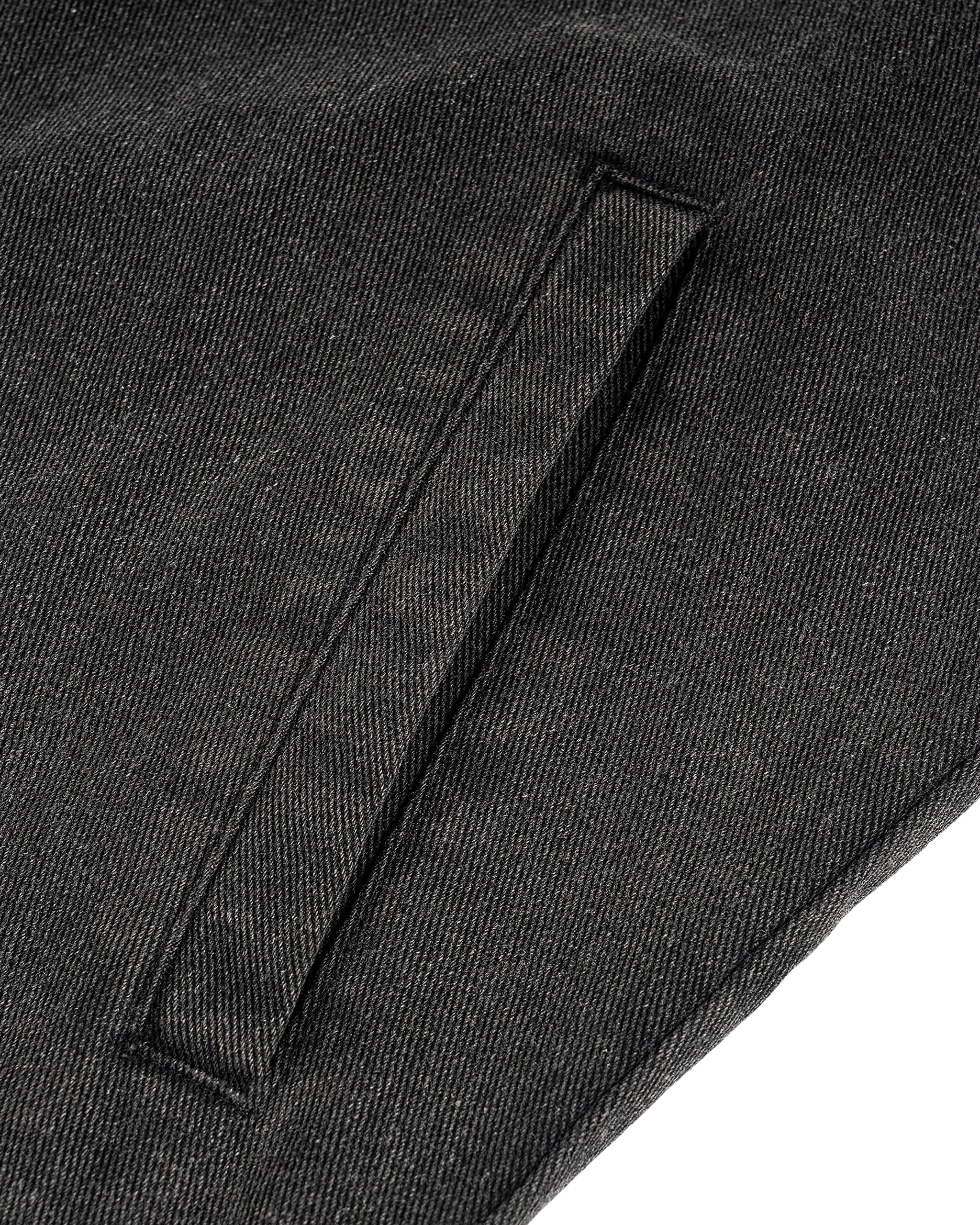 Close-up of a dark gray fabric with a pocket detail on a white background