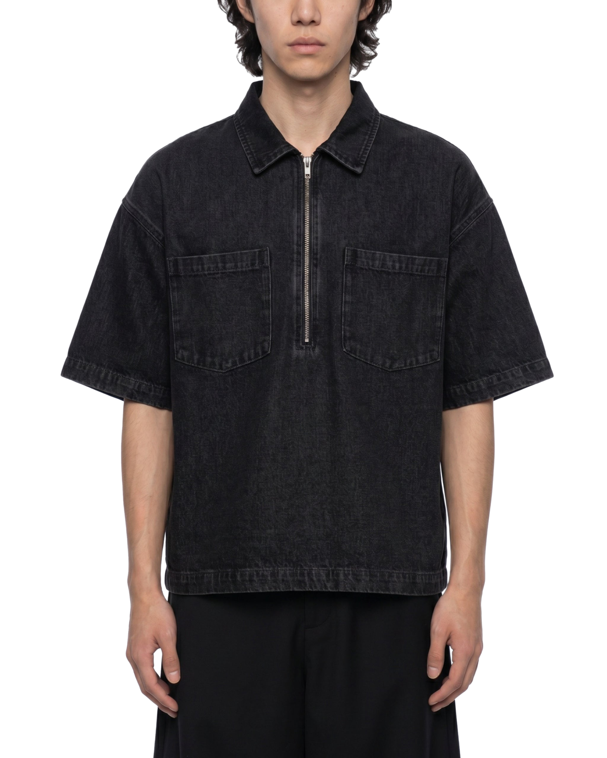 Person wearing a black short-sleeve shirt with a zipper on a white background