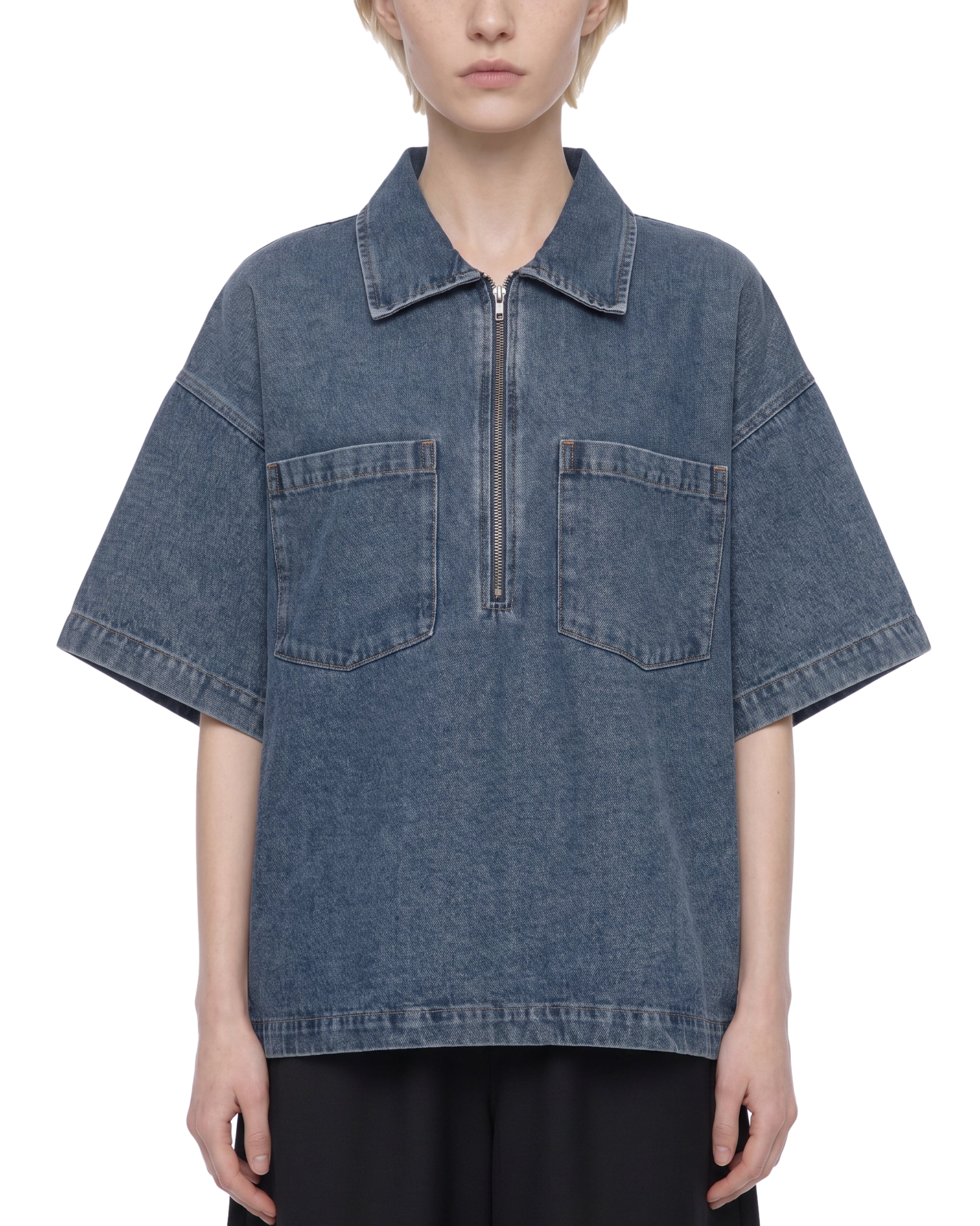 Person wearing a blue denim shirt with a white background