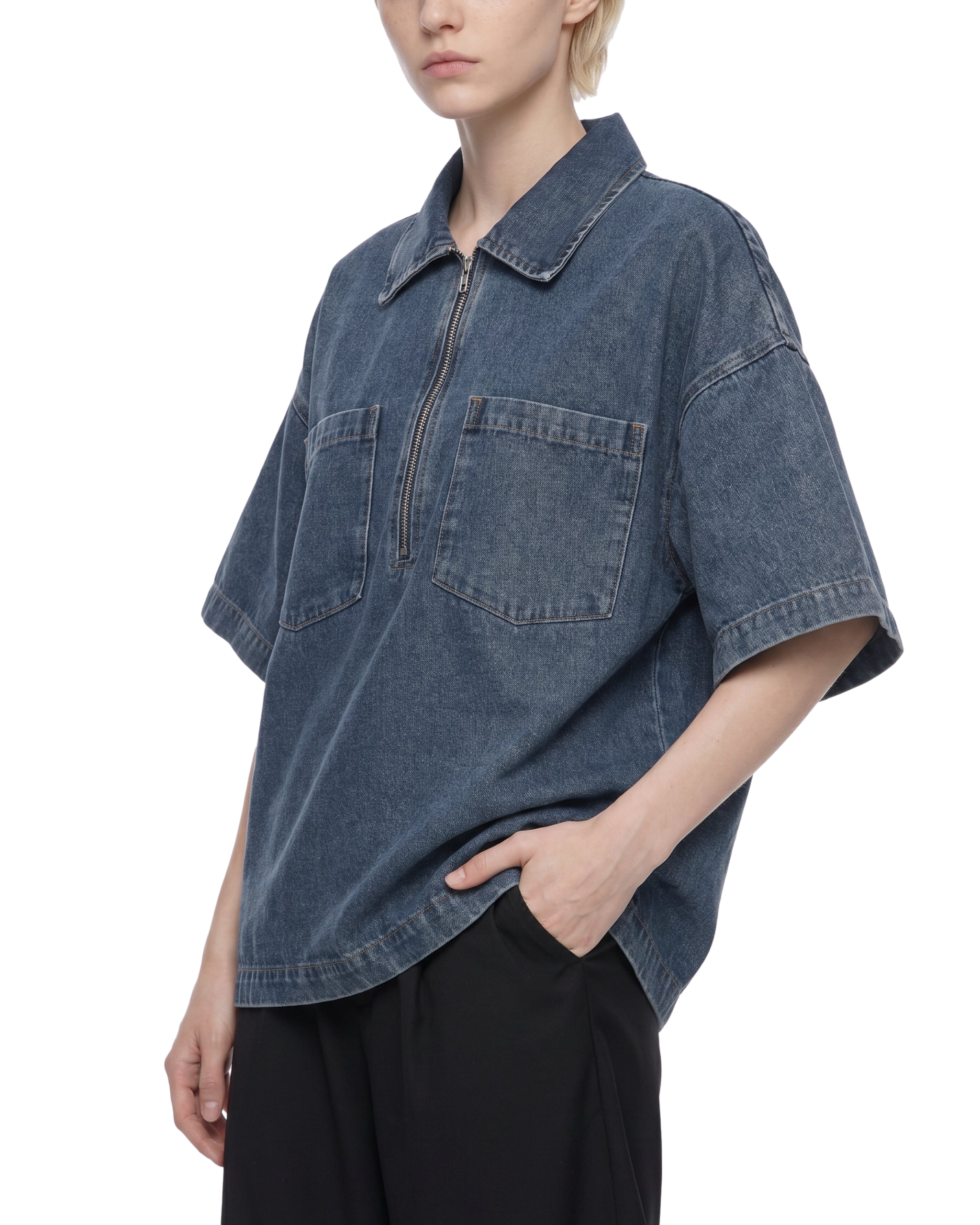 Person wearing a blue denim shirt with a white background