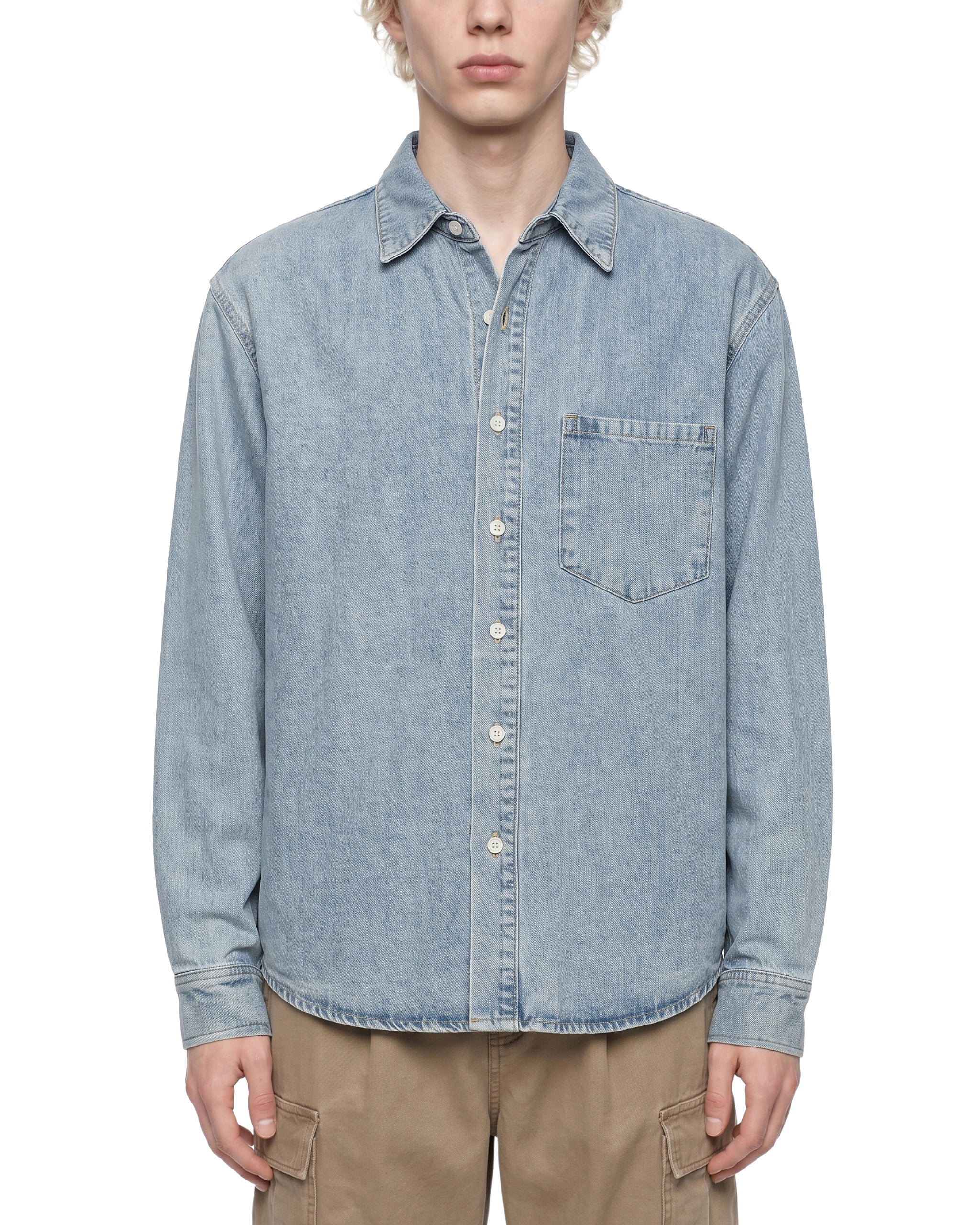 Person wearing a light blue denim shirt on a white background